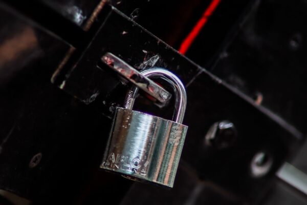 Metal padlock representing the decision between rekeying and replacing locks